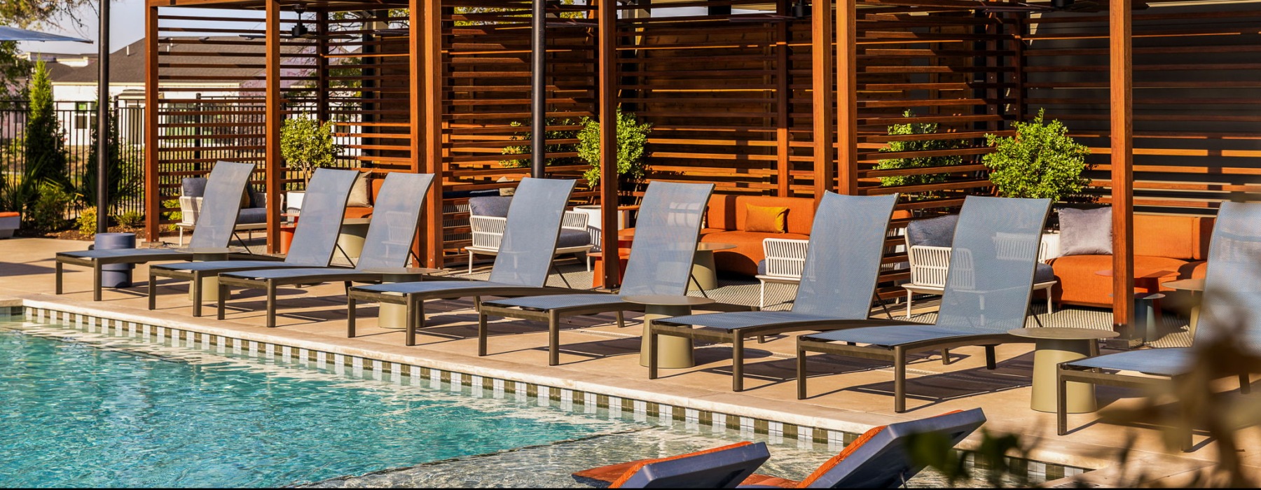 a row of lounge chairs and cabanas at the pool