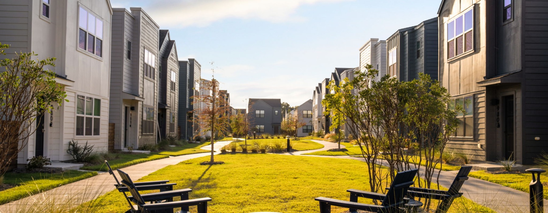 a central amenity lawn with rows of homes and seating