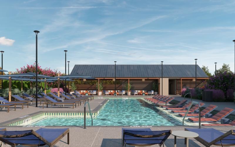 a swimming pool with chairs and a building in the background